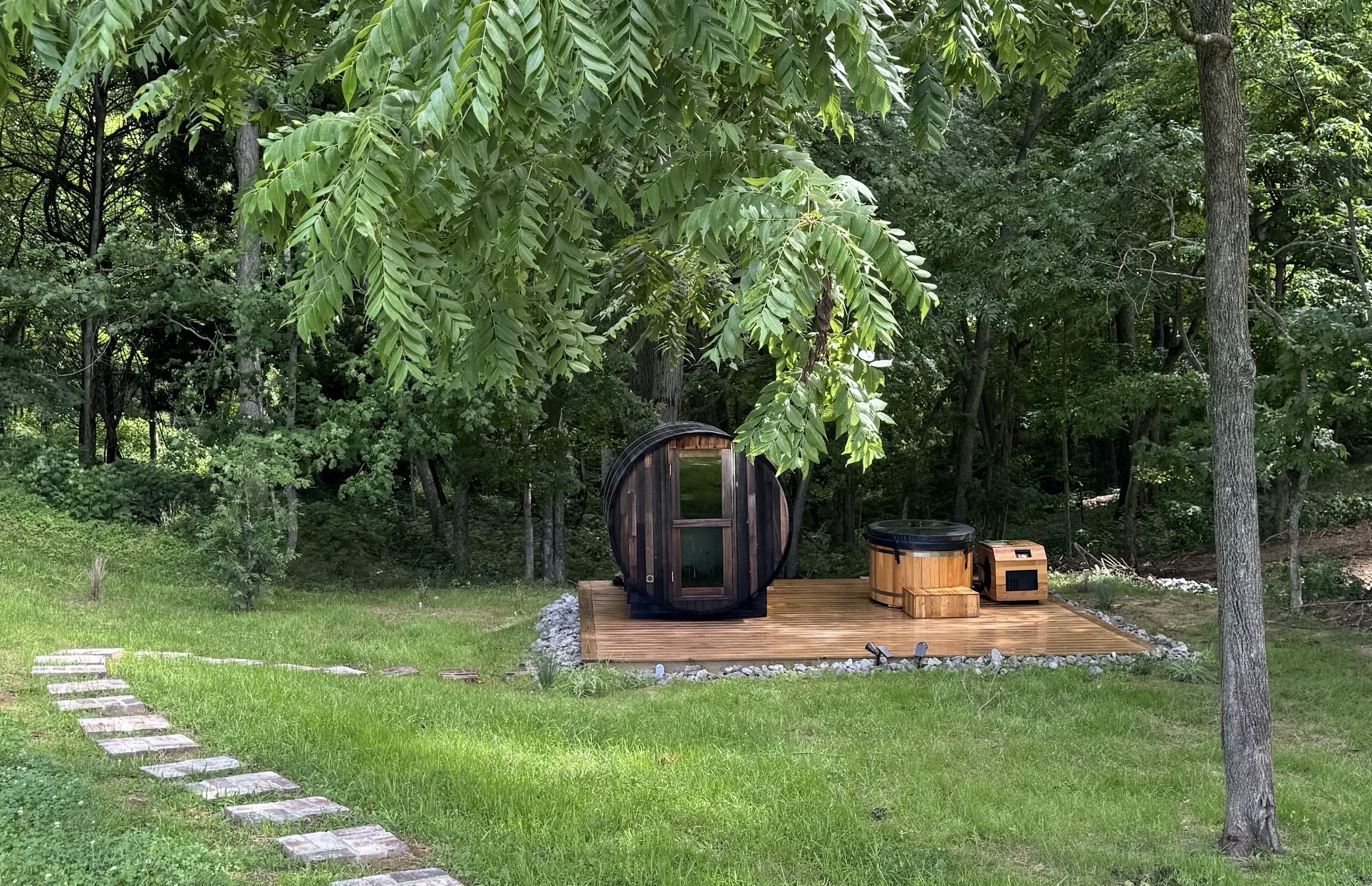 Cedar barrel sauna and cold plunge on the deck at Brookhaven, surrounded by trees